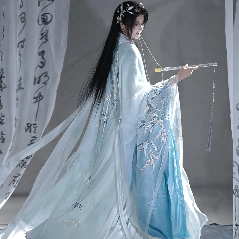 Side back view of blue men’s flowing-sleeve hanfu with long trailing coat silver bamboo embroidery and layered silhouette