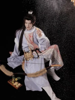Wintry Tang Dynasty hanfu male robe in pale lavender with white trim and brocade panels, posed with a traditional bow in falling snow