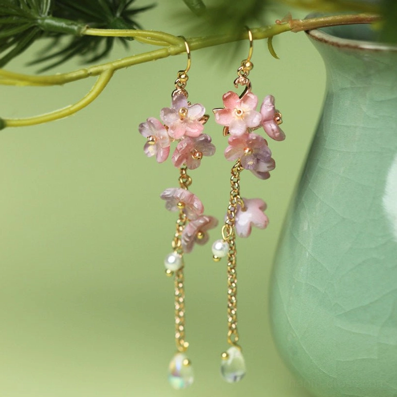 Wisteria glazed flower hook earrings hanging from pine branches with pink floral clusters, pearls and iridescent teardrop pendants