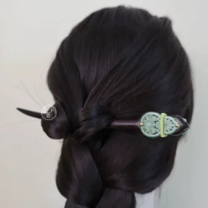 Woman wearing a traditional Chinese hair stick in a braided dark hairstyle, showing the green carved decorative head from the back