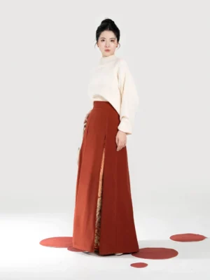Women's contemporary Chinese style two-piece outfit showing cream knit top and high-waisted maple orange Hanfu skirt with decorative inner layer
