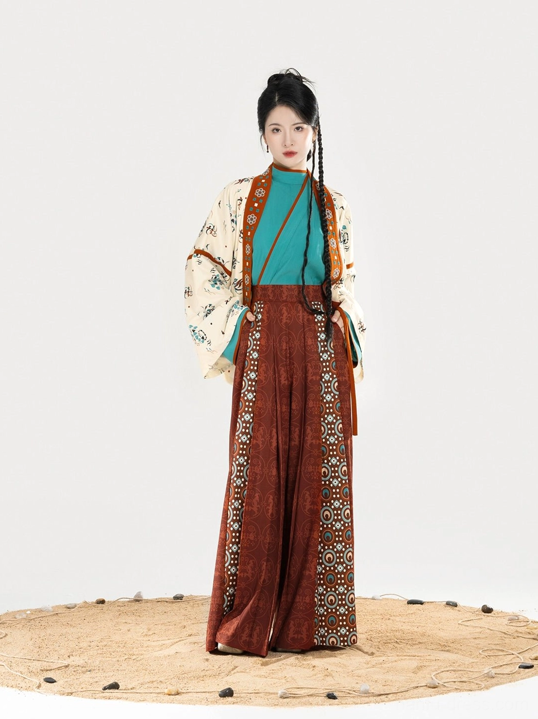 Front close-up of a layered women’s modern Hanfu outfit with tucked tops, high-waisted wide-leg pants, and traditional patterned side details