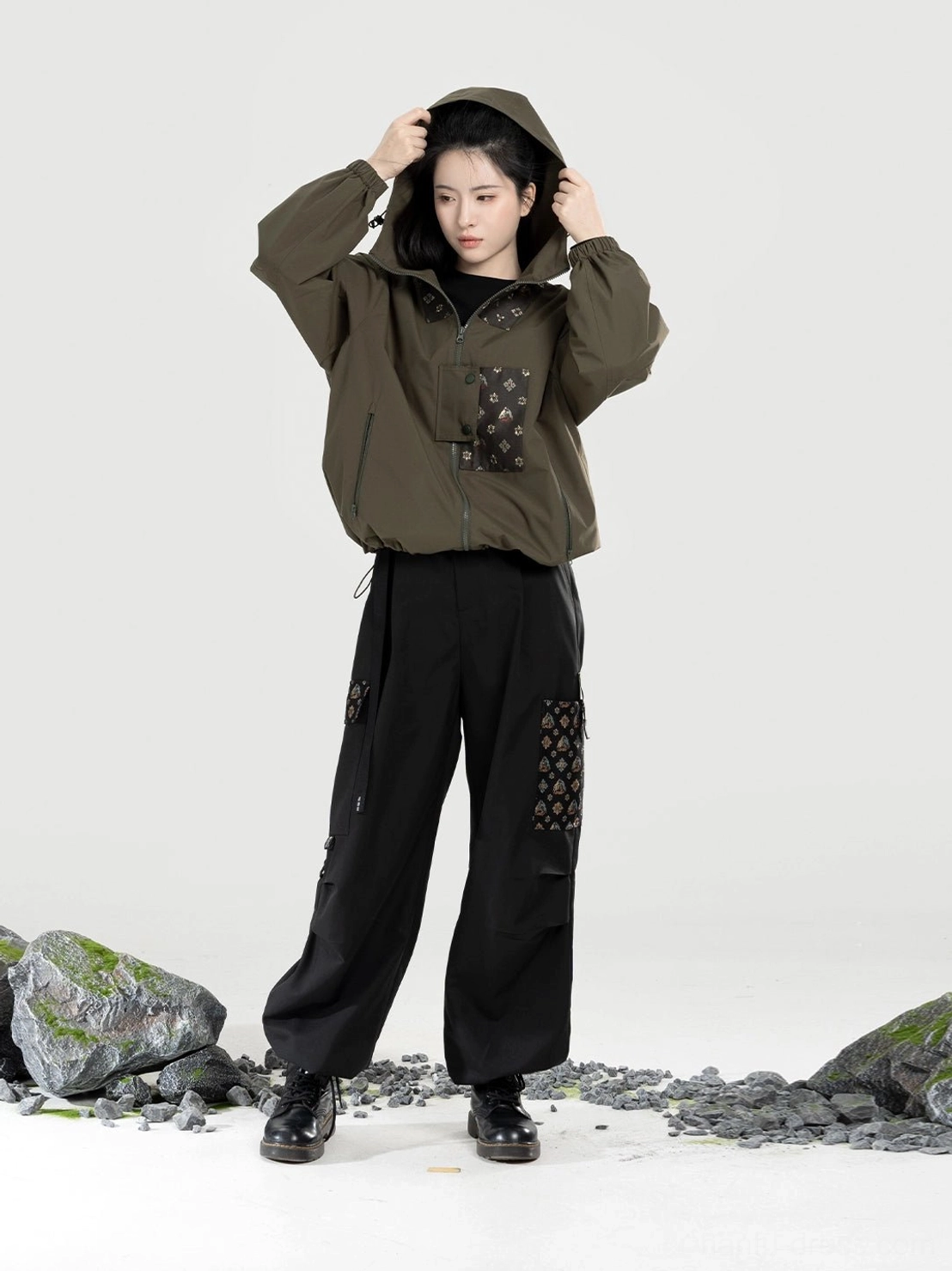 Olive green women’s Modern Hanfu hooded jacket and black relaxed straight-leg utility pants set shown in a full-body front view with traditional pattern patches