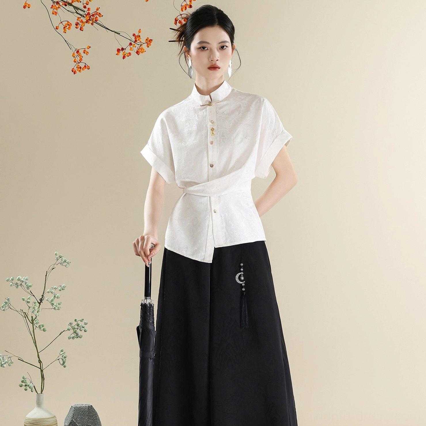 Three-quarter side view of a women's modern Hanfu clothing set with wrap-front white stand collar shirt, black wide-leg trousers, and umbrella