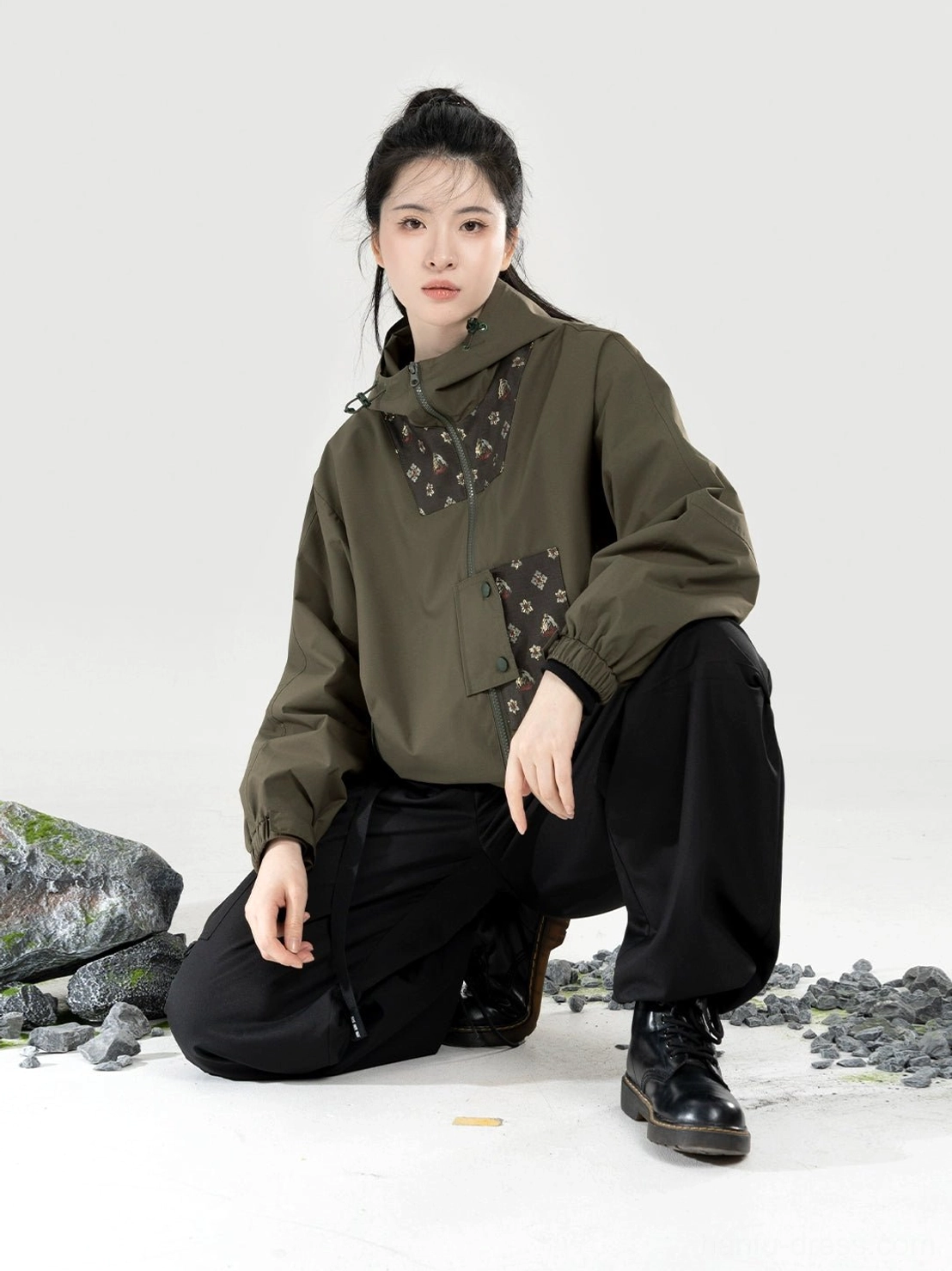 Women’s olive green Chinese-style outdoor hanfu outfit shown from a low-angle side view with decorative traditional patches on the jacket and pants