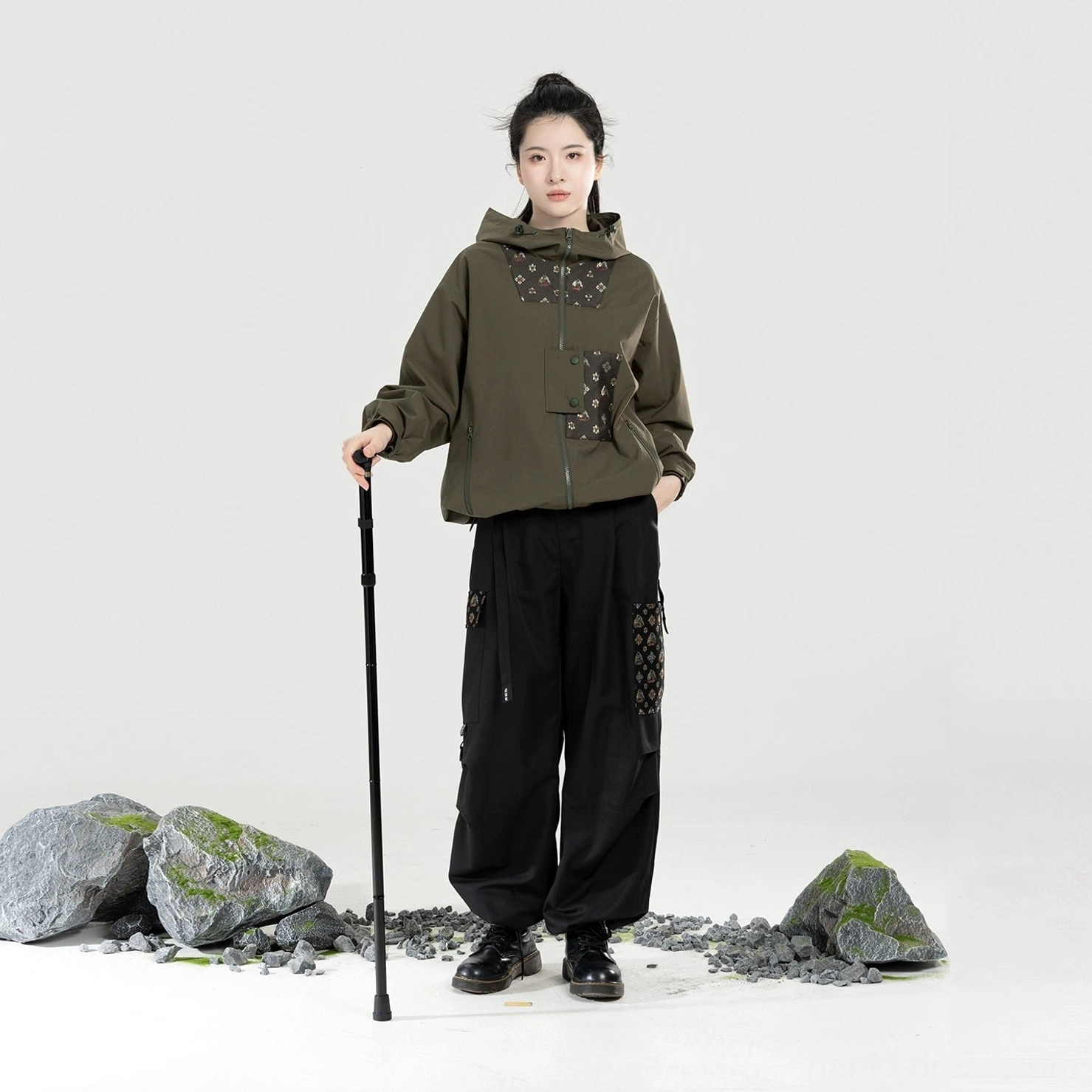 Women’s olive green Modern Hanfu outdoor hiking outfit featuring a hooded jacket relaxed utility pants and coordinated traditional pattern accents