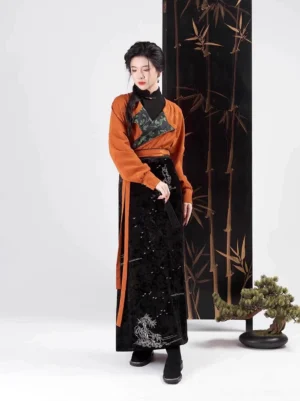 Front three-quarter view of a women's Song Dynasty Hanfu outfit with dark green chest panel, orange long sleeve top, and silver embroidered skirt hem