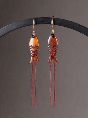 Wooden fishbone tassel Chinese earrings with brown and red bead details displayed from the front