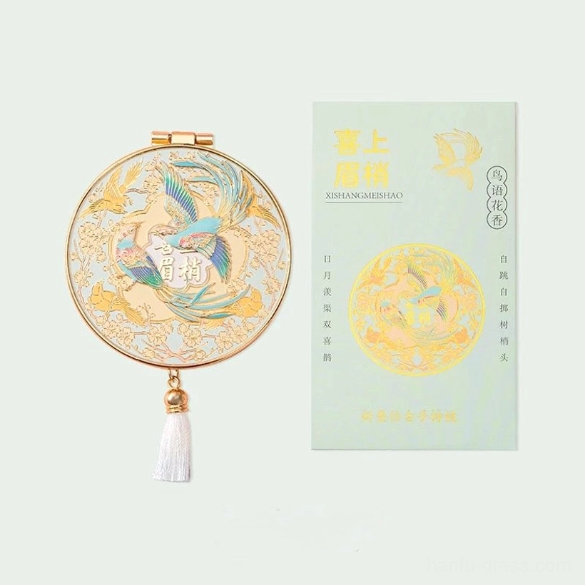 Xi Shang Mei Shao Chinese folding pocket mirror with bird and calligraphy artwork, gold-tone frame, white tassel, and light green cultural gift card