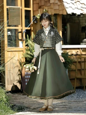 Xiangling modern Hanfu outfit front view with houndstooth cropped vest white puff sleeve shirt and dark green tassel midi skirt