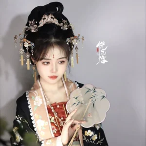 Xiangsi vintage Hanfu hair accessories set worn with floral traditional Chinese Hanfu and a painted round Chinese hand fan, featuring a golden crown, pearl accents, jeweled hairpins, tassels, and matching earrings