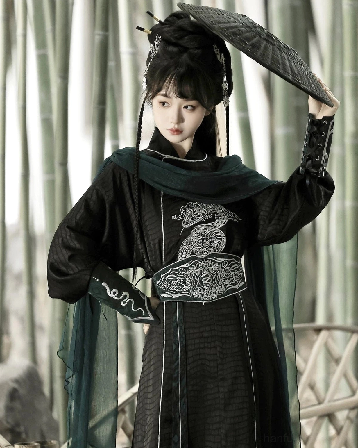 Close-up of silver snake chest and waist embroidery on a black xianxia Hanfu costume with dark green scarf and layered traditional Chinese styling