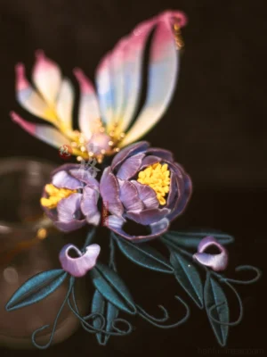 Close-up flat lay of a purple peony butterfly silk coiling flower hair pin with green leaves curling vines and gradient pink yellow wings