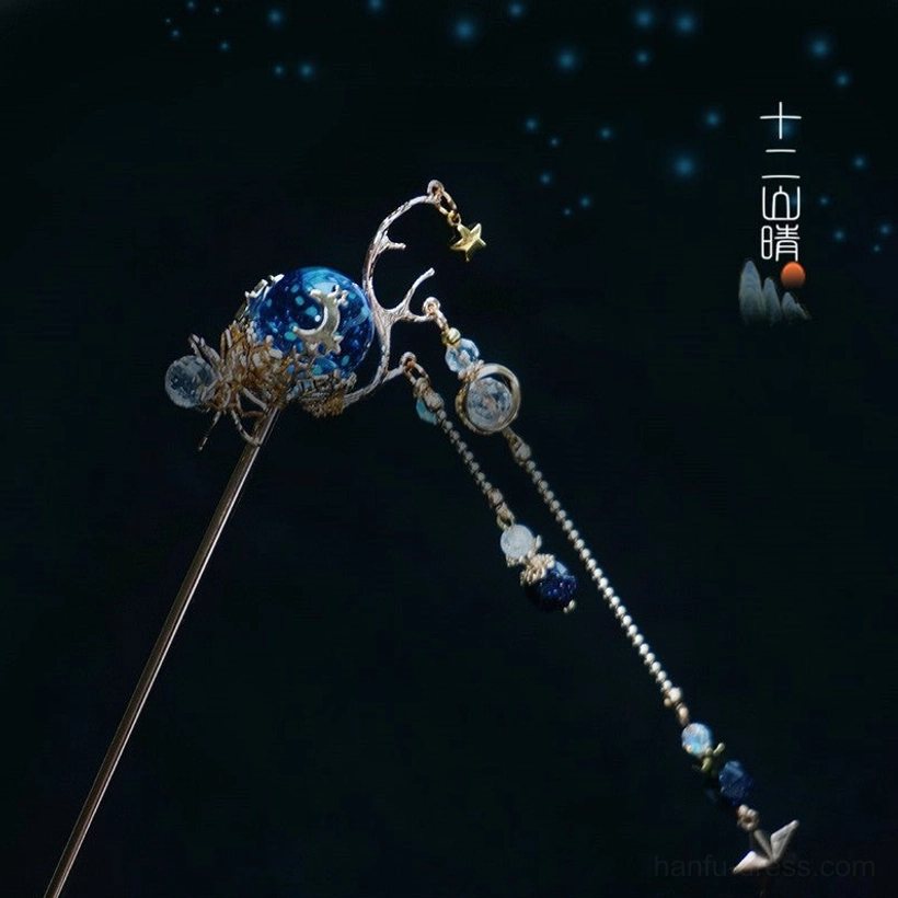 Front close-up of Xingyue celestial Chinese hair stick featuring a galaxy blue bead, gold antler inspired decoration, beaded tassels, and star pendants