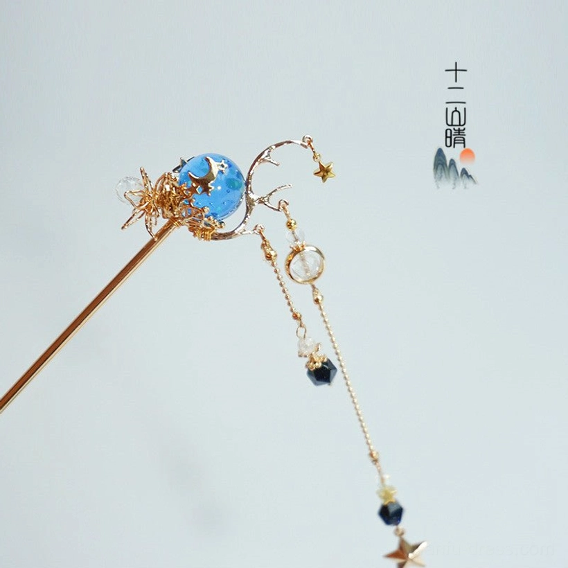 Side view of Xingyue traditional Chinese hairpin with blue starry sky centerpiece, gold tone floral metalwork, dark bead, and dangling star chain tassel