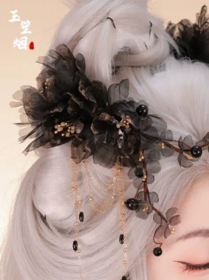 Side close-up of the Xuanming Chinese hairpin secured in a silver-gray updo showing black sheer flowers gold hardware and water-drop tassels