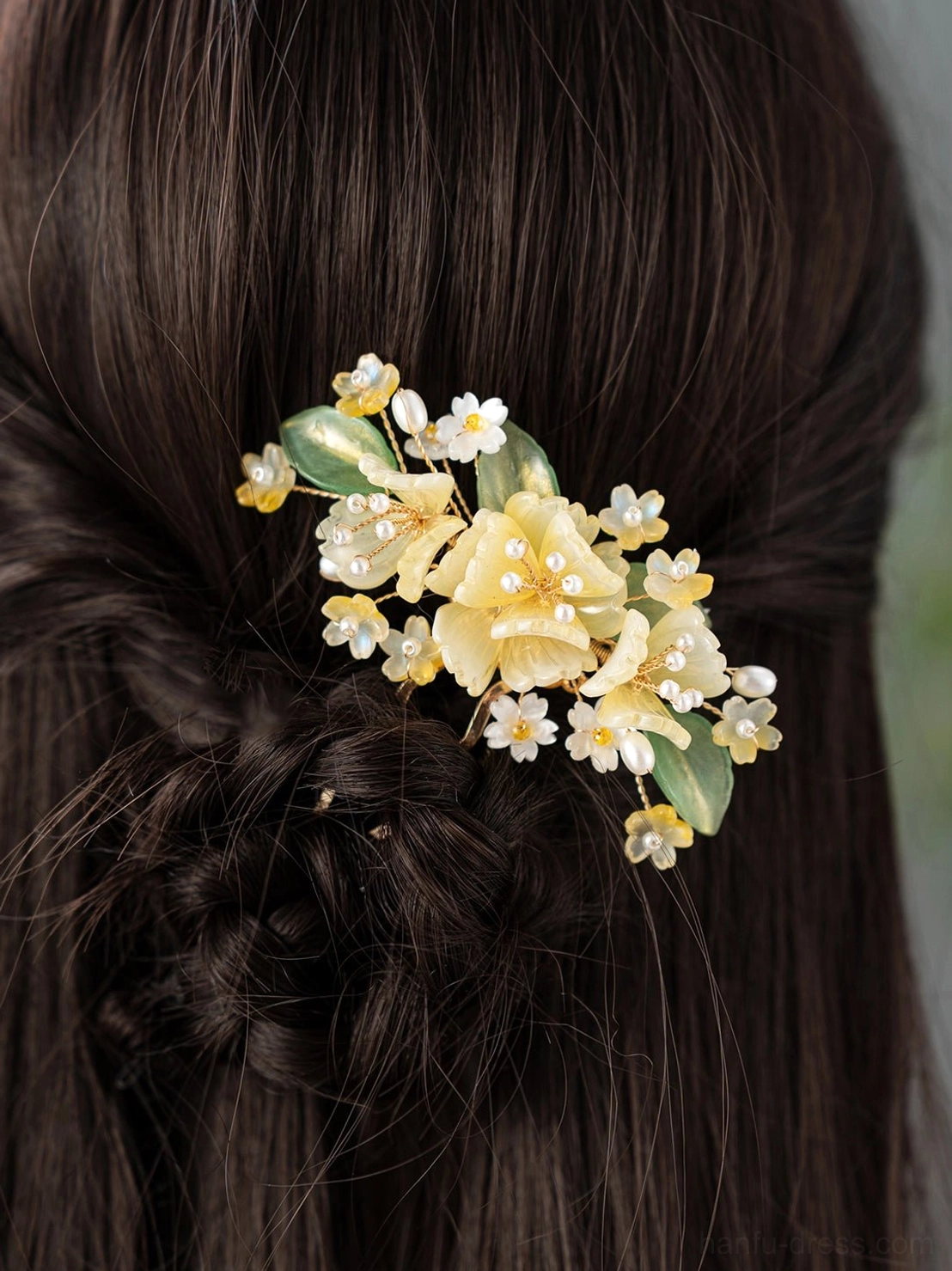 Yellow floral Hanfu side hair clip worn with a dark brown braided hairstyle showing the elegant Chinese-inspired hair ornament design