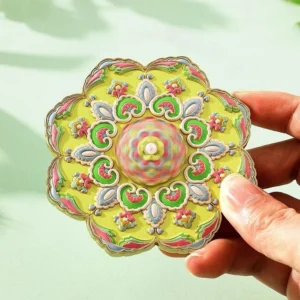 Close-up of yellow lotus mandala Chinese hand mirror with colorful floral enamel-style pattern and gold-toned petal edges
