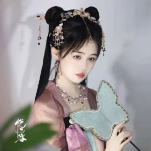 Model wearing Yexian gold tone Hanfu hair accessory set with floral tassels and a butterfly Chinese hand fan