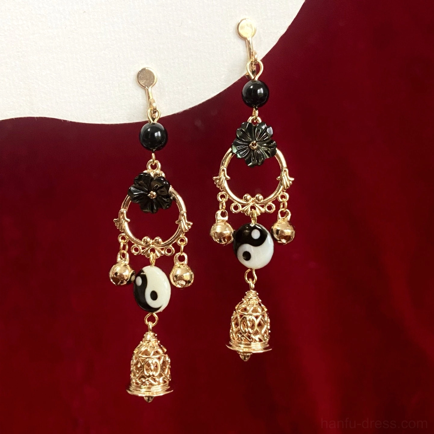 Pair of Yin Yang Tai Chi hook drop earrings for Hanfu featuring gold tone metal black flower accents round charms and hollow bell dangles