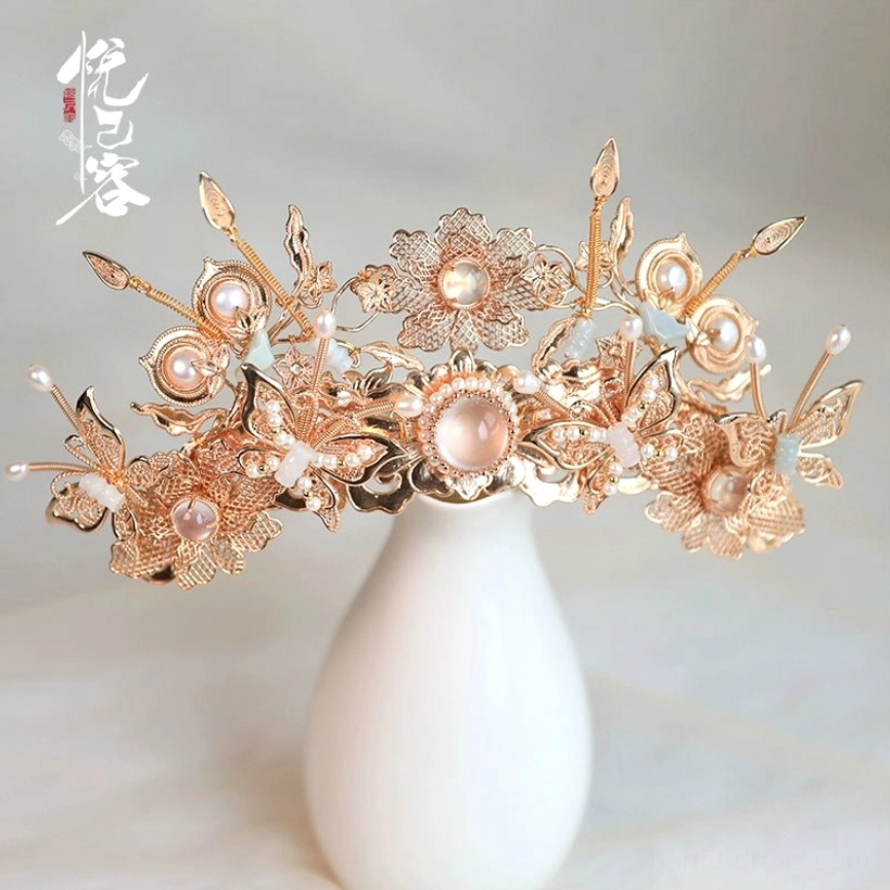 Close-up of a Yunhuali hanfu side hair cluster featuring gilt filigree flowers, a central faux gem, pearl details, and pink and white stones