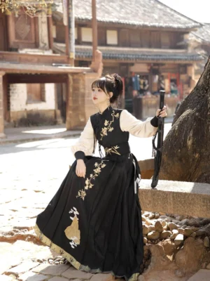 Yunshan modern Hanfu wuxia three-piece outfit in black and ivory with gold mountain embroidery, shown in a traditional Chinese street with a sword