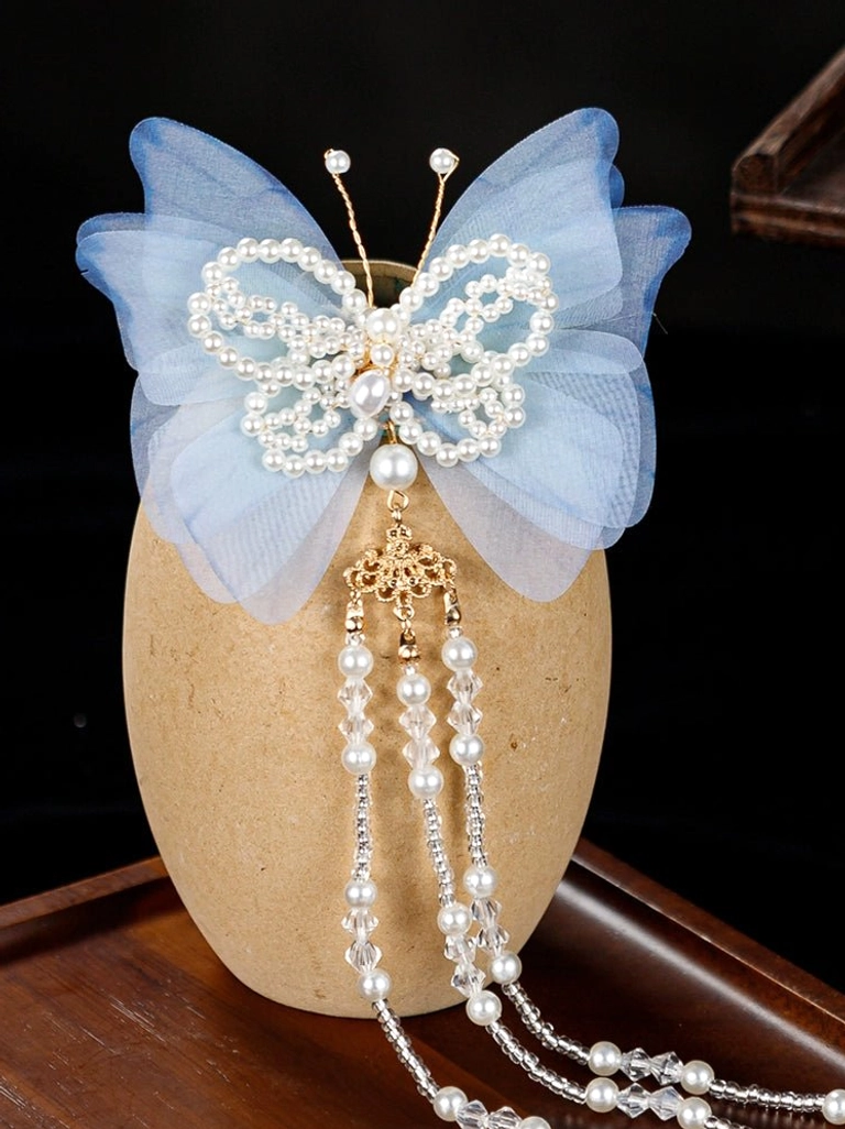 Close up of Zhuang Mengdie blue butterfly Hanfu hair pin showing pearl center gold tone pendant and cascading bead tassels