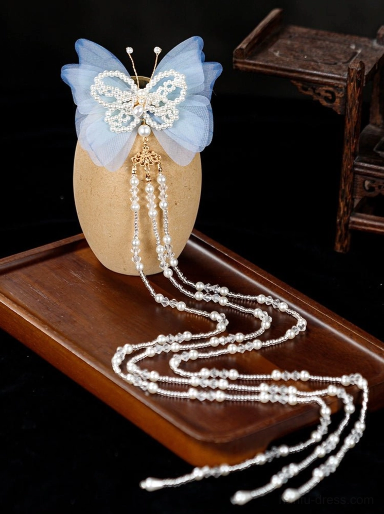 Light blue butterfly tassel Hanfu hair pin with pearl style center and gold tone details displayed on a Chinese inspired table