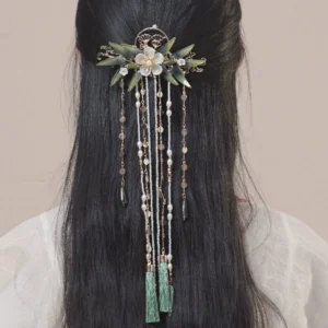 Back view of a model wearing the Zhuqin Chinese tassel hairpin with white jade-like flowers, green bamboo ornaments, layered beaded tassels, and dark green pendants with light Hanfu