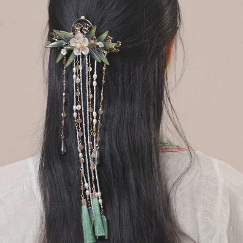 Back right side view of a model wearing the Zhuqin Hanfu hairpin with white flowers, green bamboo-inspired ornaments, layered beads, and swinging tassel pendants
