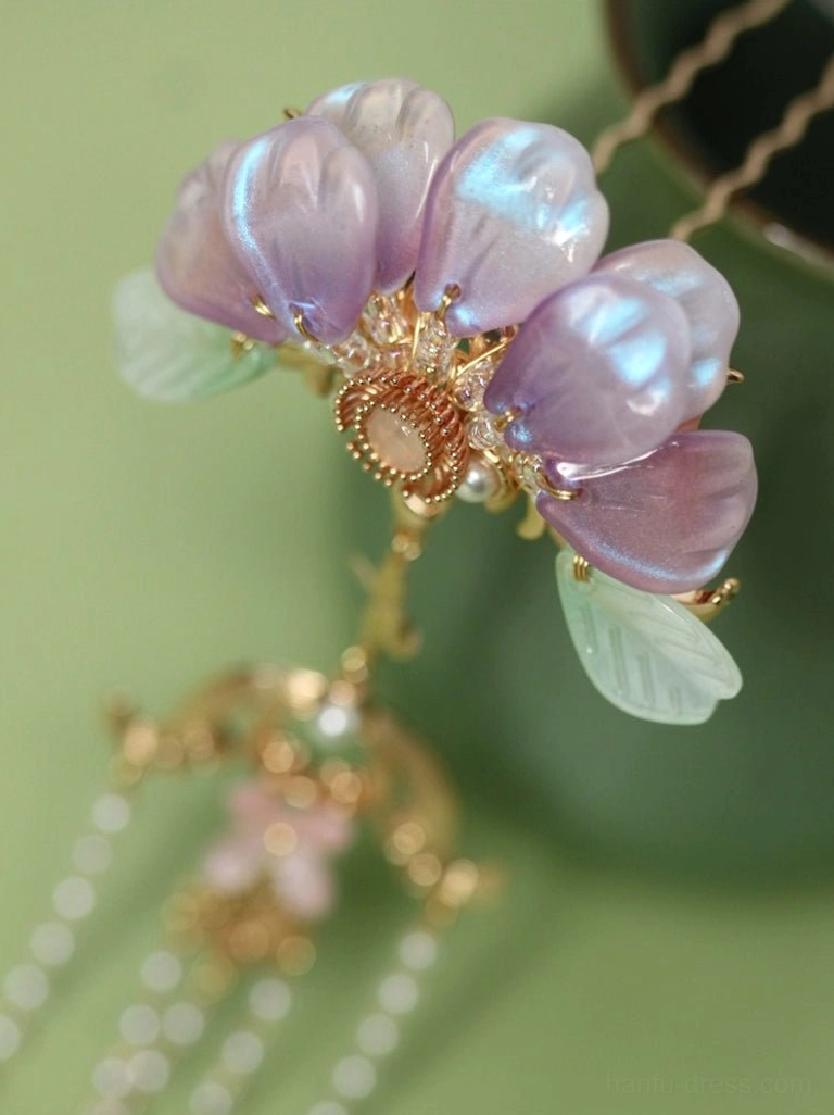 Close-up of Zixuan Chinese tassel hair pin showing pearlescent purple flower petals carved gold tone metal base translucent green leaves and detailed pearl tassel