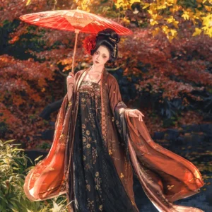 Late Tang Dynasty qixiong ruqun Hanfu set with grand wide brown sleeves, black and gold floral breast-high skirt, matching shawl, and red oiled paper umbrella in an autumn maple forest